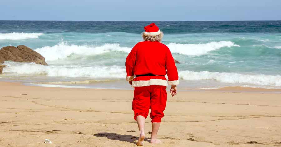 man in red suit walking on beach sand